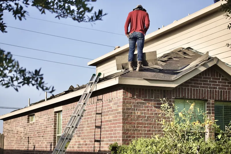 Professional roofer working on a residential roof in Gates